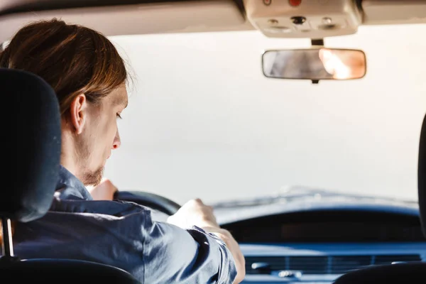 Jongeman met lang haar rijden auto — Stockfoto