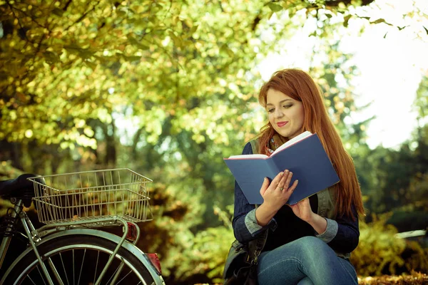 Молода леді читає книгу в парку . — стокове фото