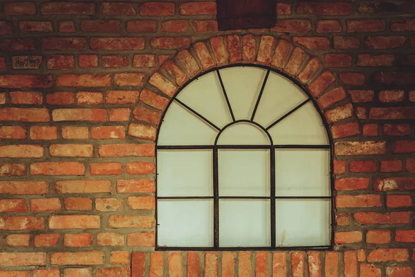 Grande fenêtre arrondie sur mur de briques rouges — Photo