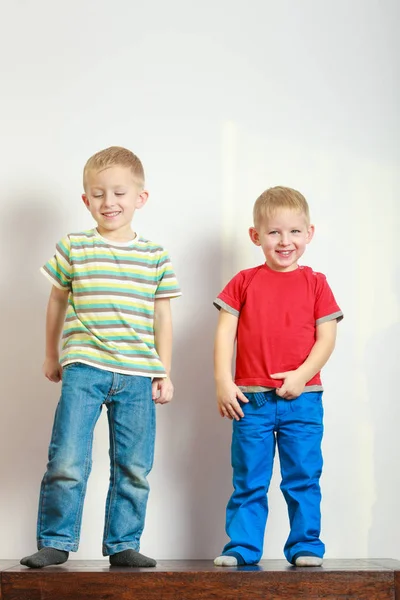 Two little boys siblings playing together on table — Stock Photo, Image