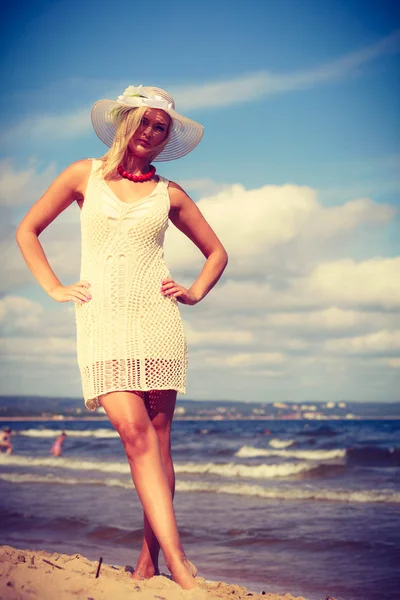 Blonde vrouw dragen jurk wandelen op strand — Stockfoto