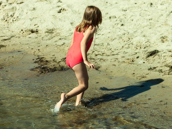 Malé batole dívka hraje na pláži — Stock fotografie