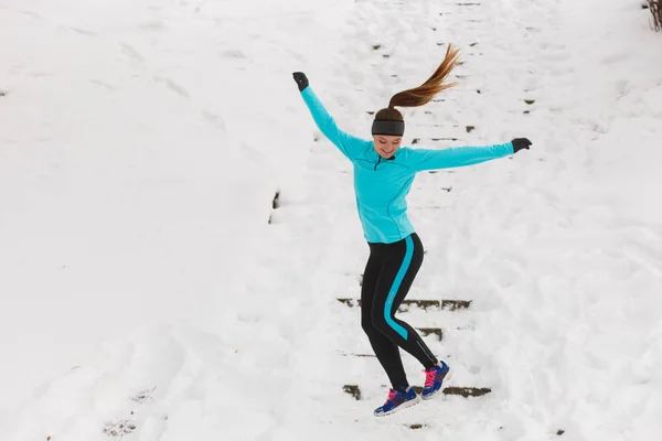 Giovane ragazza che salta sulla neve . — Foto Stock