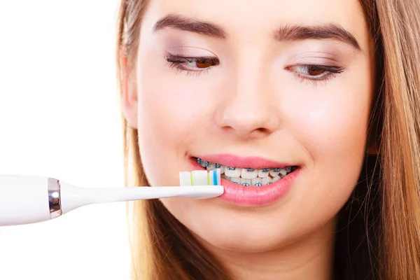 Žena čištění zubů s rovnátkama pomocí štětce — Stock fotografie