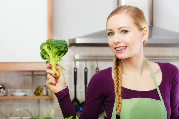 Женщина на кухне с зеленой свежей брокколи — стоковое фото