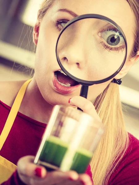 Zszokowana kobieta patrząc przez Lupa o zielony sok — Zdjęcie stockowe