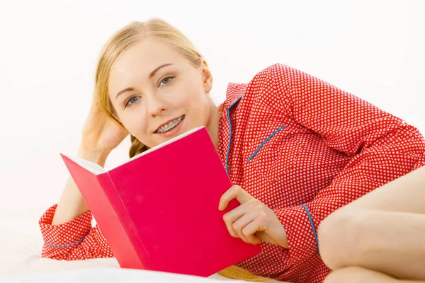 Vrouw in bed lezen boek ontspannen — Stockfoto