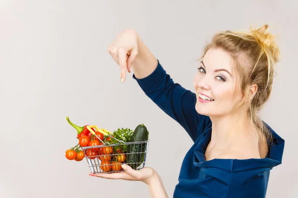 Vrouw houdt winkelmandje met groenten — Stockfoto