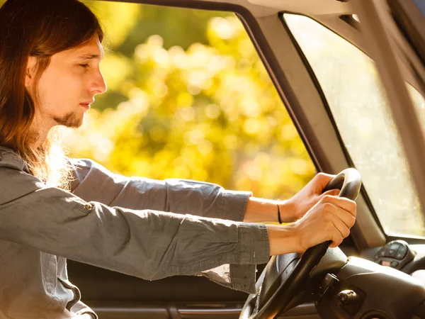 Young man with long hair driving car — Stock Photo, Image