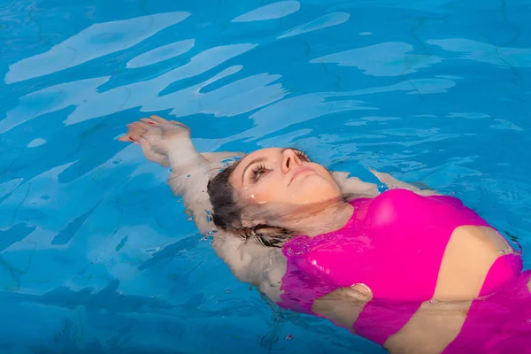 Красива жінка плаває в басейні — стокове фото