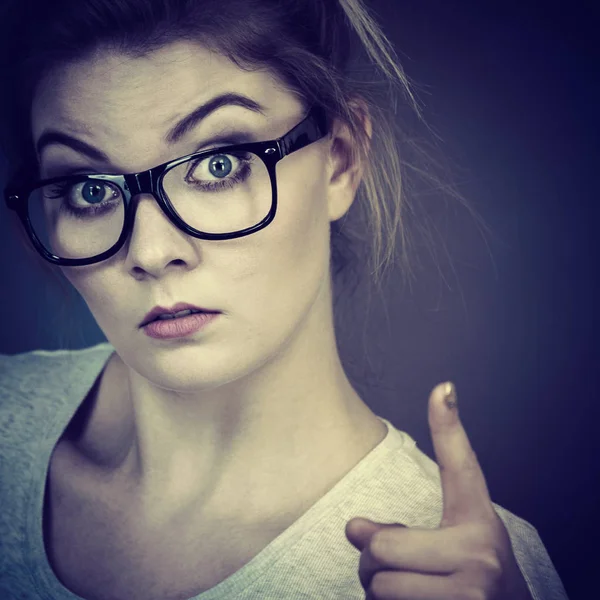 Kvinna som bär glasögon pekar på kamera — Stockfoto