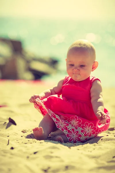 Pequeño bebé sentado y jugando en la playa — Foto de Stock