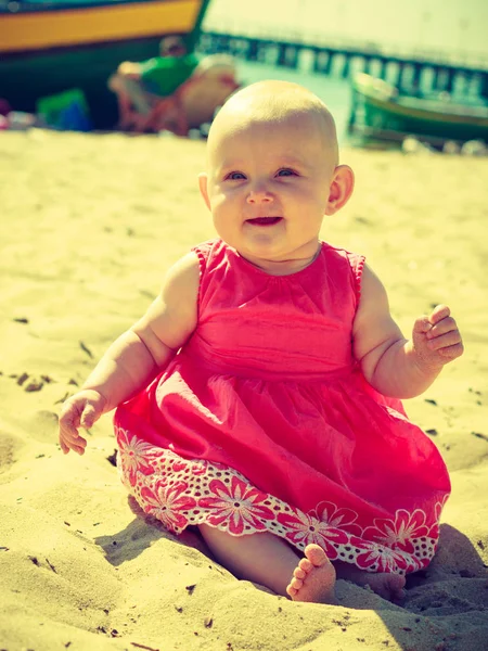 Pequeno bebê sentado e brincando na praia — Fotografia de Stock