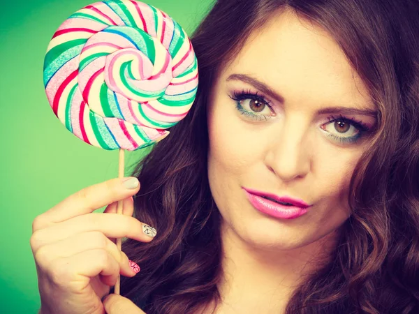 Smiling girl with lollipop candy on green — Stock Photo, Image