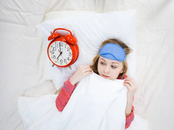 Donna scioccata indossando pigiama che tiene orologio dormito troppo — Foto Stock