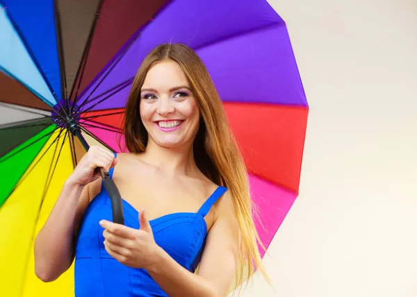 Frau im Sommerkleid hält bunten Regenschirm in der Hand — Stockfoto