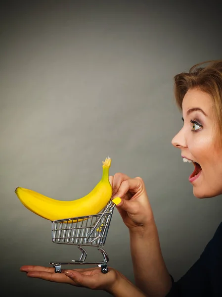 Kvinna med kundvagn med banan inne — Stockfoto