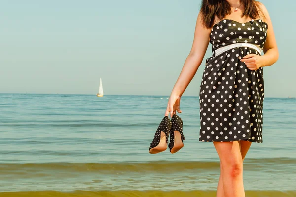 Frau im Retro-Kleid mit Schuhen am Meer — Stockfoto