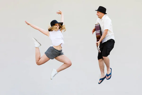 Man met de gitaar en vrouw springen — Stockfoto