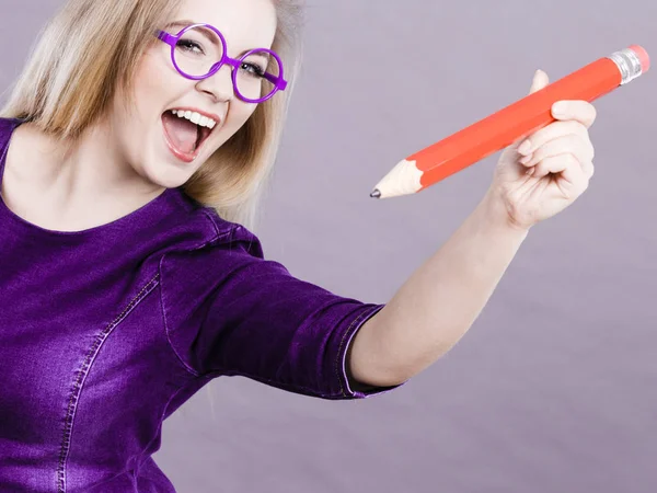 Mulher feliz segurando grande lápis de grandes dimensões — Fotografia de Stock