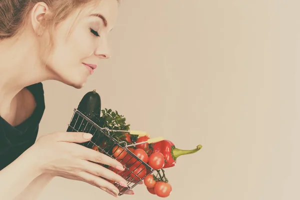 Жінка тримає кошик з овочами, пахне — стокове фото