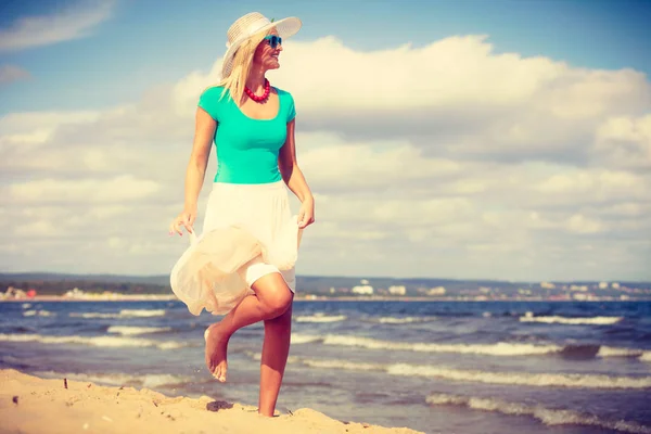 Mujer rubia usando vestido caminando en la playa —  Fotos de Stock