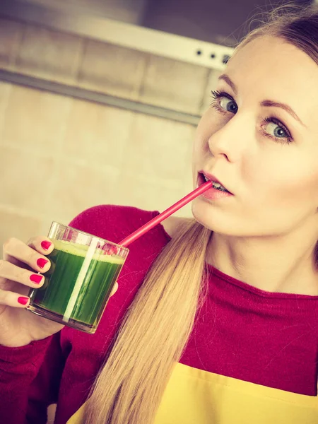 Woman in kitchen holding vegetable smoothie juice — Stock Photo, Image