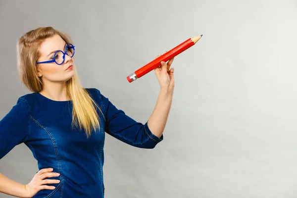 Серйозна жінка тримає великий олівець в руці — стокове фото