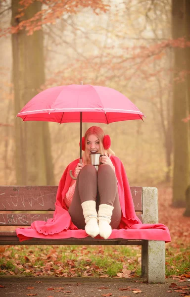 Girl in autumn park enjoying hot drink — Stock Photo, Image