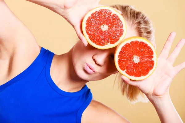 Mulher segurando toranja citrinos nas mãos — Fotografia de Stock