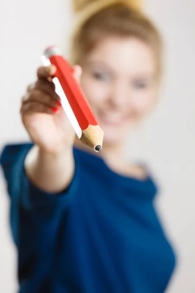 Gelukkige vrouw met grote potlood geven — Stockfoto