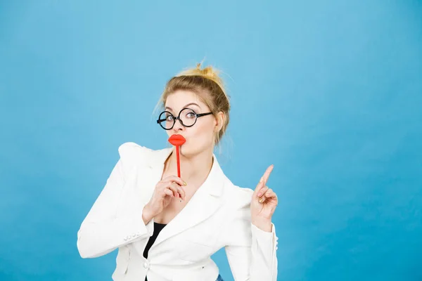 Женщина держит фальшивые губы на палочке указывая на пространство для копирования — стоковое фото