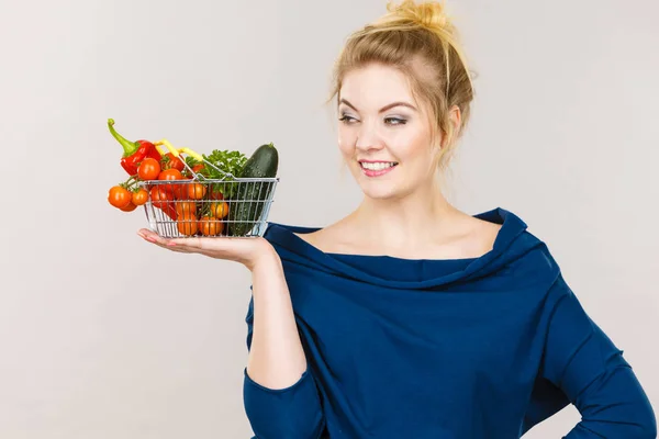 Femme tient panier avec des légumes — Photo