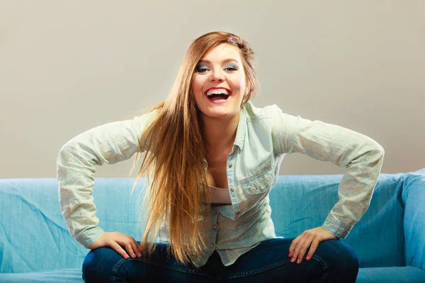 Fashionable girl wearing denim sitting on couch. — Stock Photo, Image