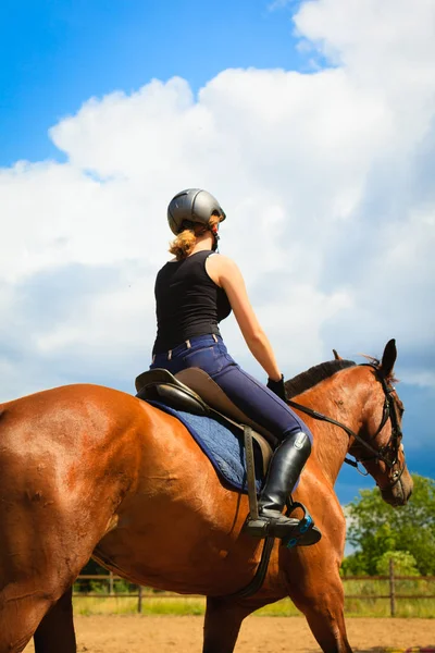 Jockey girl gör häst ridning på landsbygden äng — Stockfoto