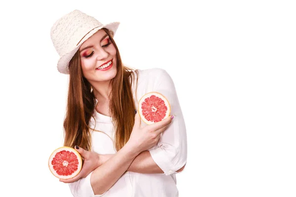 Kobieta trzyma dwie połówki owoców cytrusowych grejpfruta w rękach — Zdjęcie stockowe