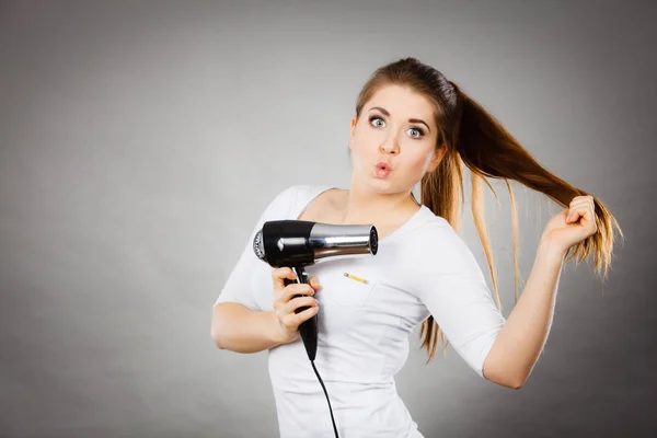 Mujer secándose el cabello usando secador de pelo —  Fotos de Stock