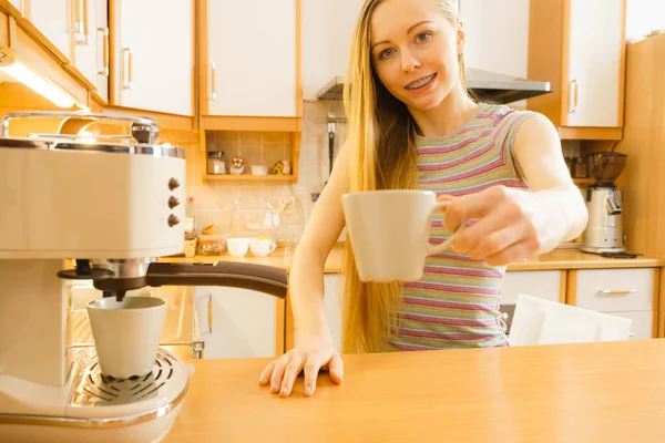 Frau in Küche kocht Kaffee aus Maschine — Stockfoto