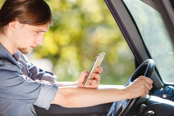 Mannen som använder sin telefon när han kör bil. — Stockfoto