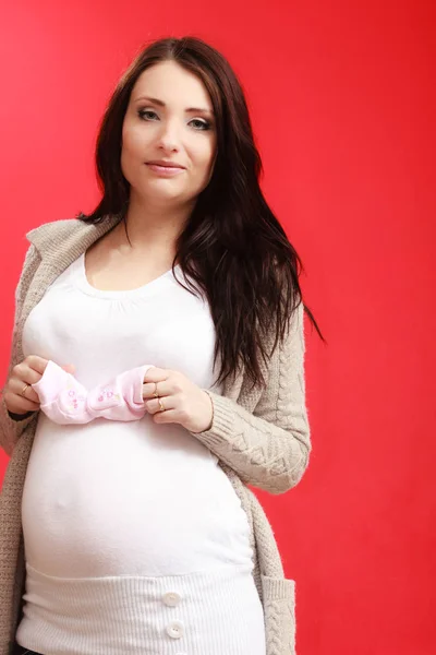 怀孕的妇女抱着小宝宝鞋 — 图库照片