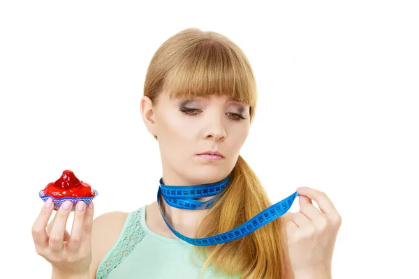 Woman holds cupcake trying to resist temptation — Stock Photo, Image