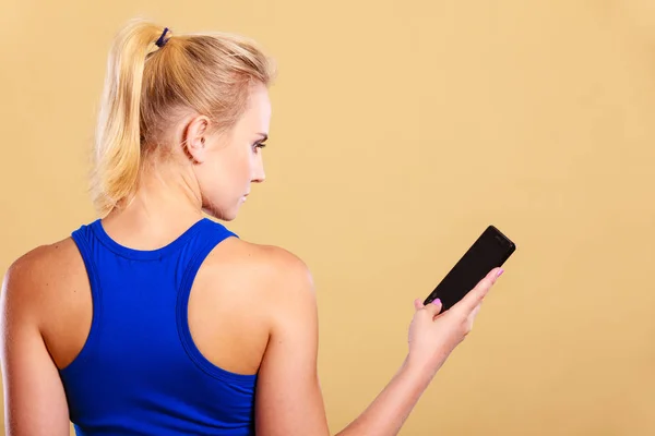 Deportiva usando teléfono móvil en el gimnasio . —  Fotos de Stock