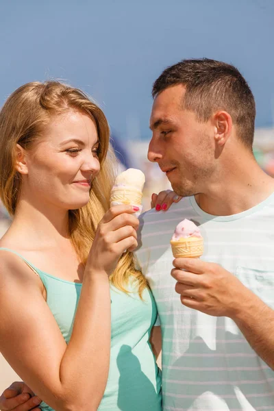 Mężczyzna i kobieta jedzący lody na plaży — Zdjęcie stockowe