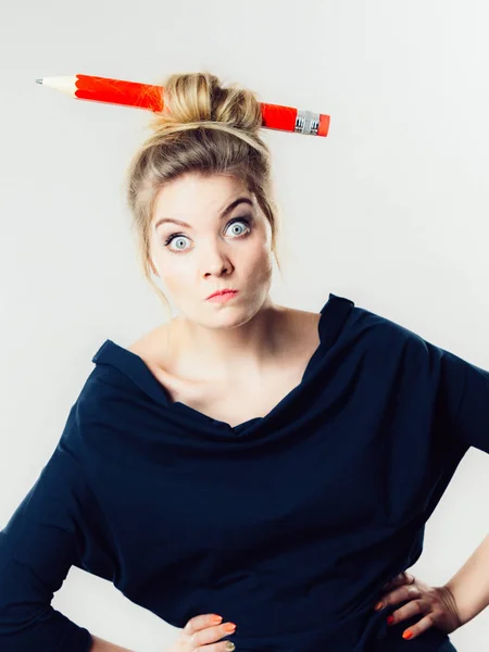 Confused blonde woman having big pencil in hair — Stock Photo, Image