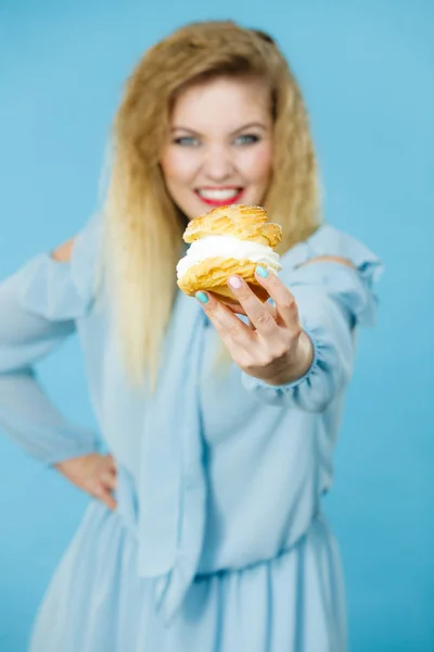 Funny woman holds cream puff cake — Stock Photo, Image