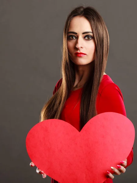 Chica sosteniendo corazón rojo signo de amor — Foto de Stock