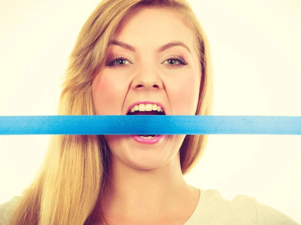 Attractive blonde woman biting tape on mouth. — Stock Photo, Image
