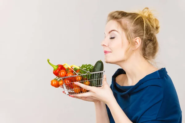 女性の臭いがする野菜、買い物カゴを保持しています。 — ストック写真