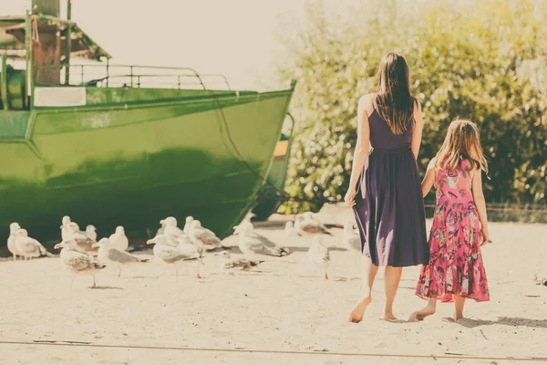 母亲和女儿在海滩附近的船上 — 图库照片