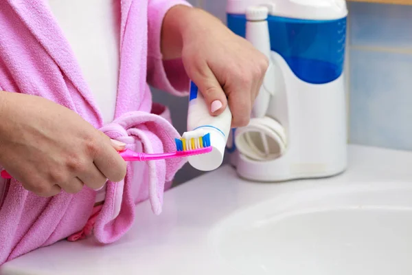 Hand tillämpas tandkräm på tandborsten — Stockfoto